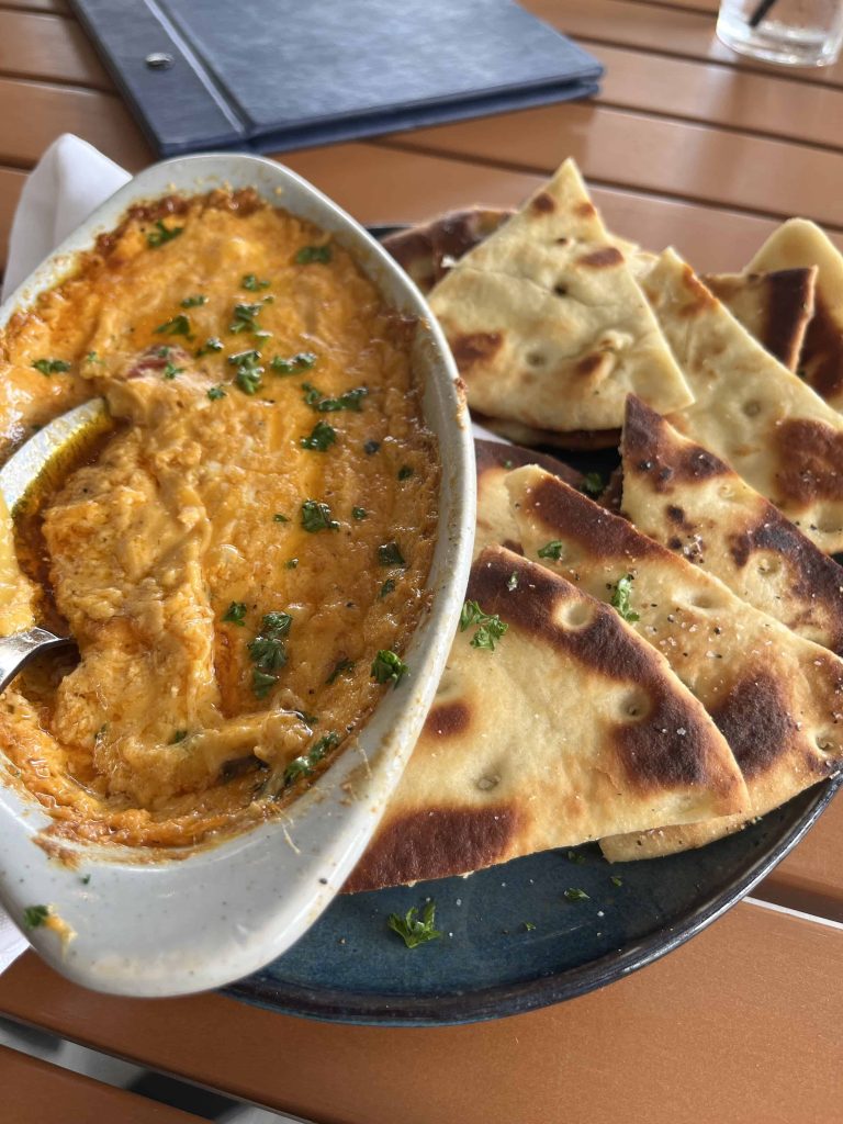 Pimento cheese dip in a dish with pita chips on side