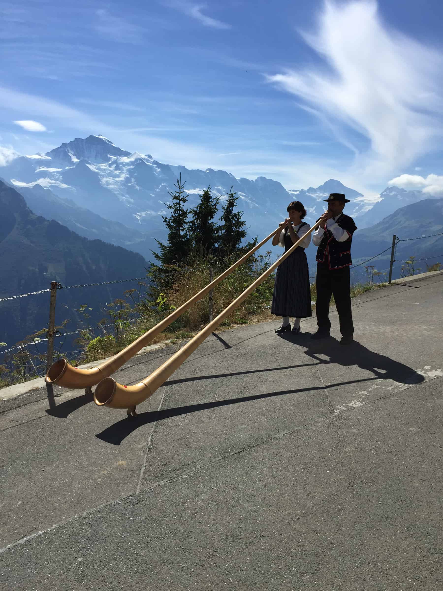 Alphorn being played on a mountain side in the sun