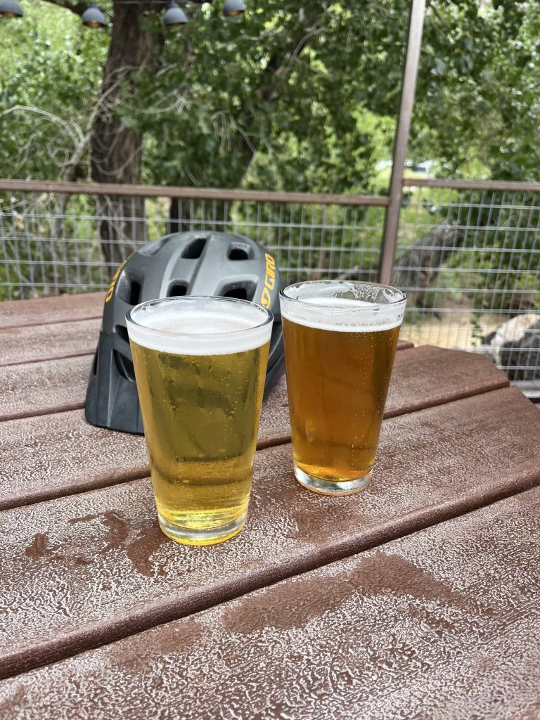 Two beers on table with bike helmet in Zion Park