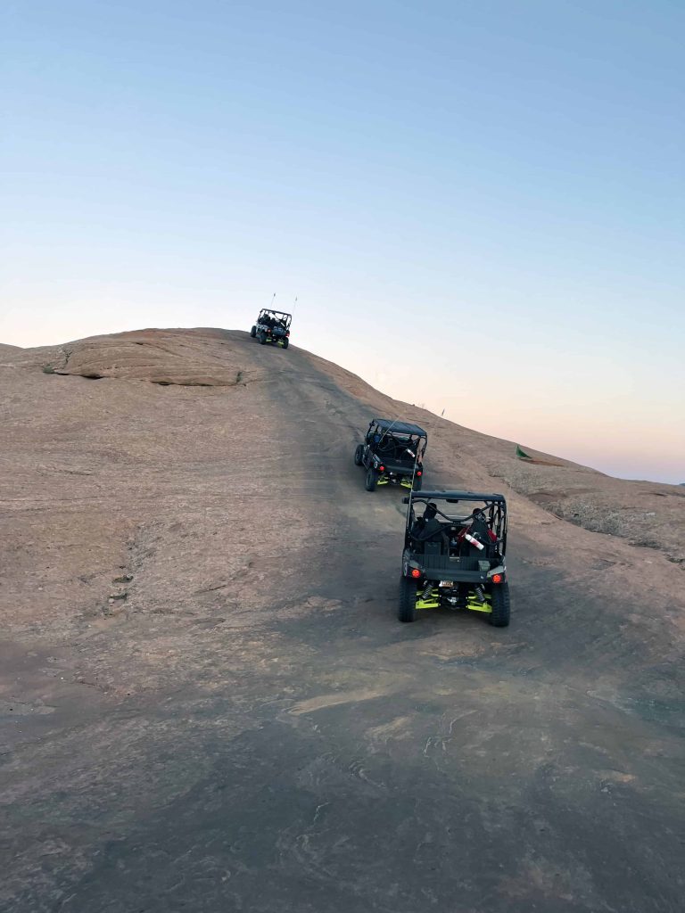 4x4 vehicles driving up a large hill in Moab's Hell's Revenge