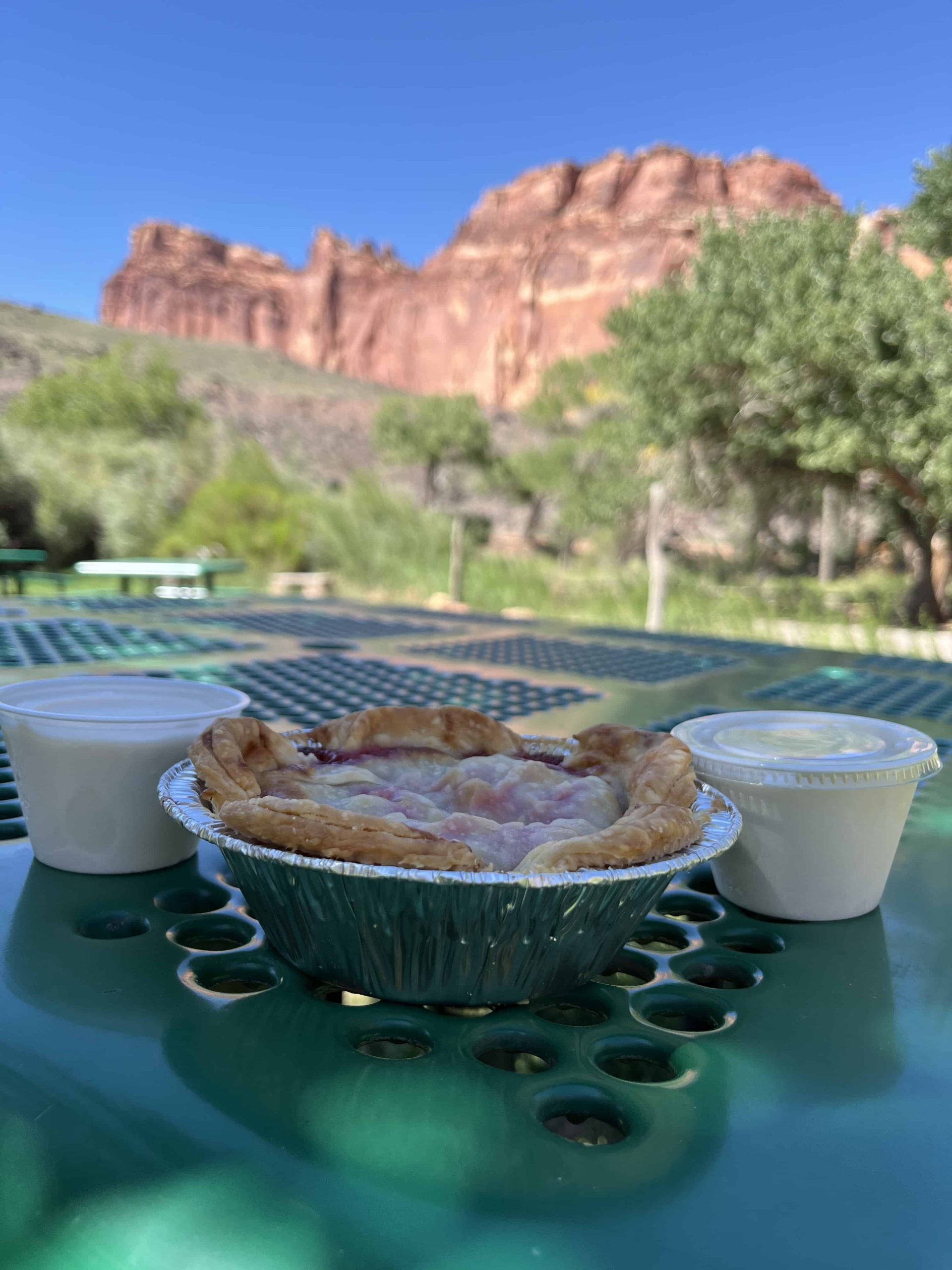 Fruit pie on table with red rocks in background