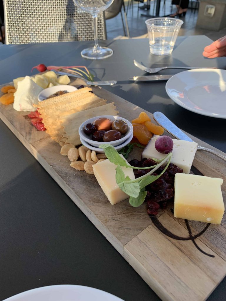 Wine tasting on patio with cheese board