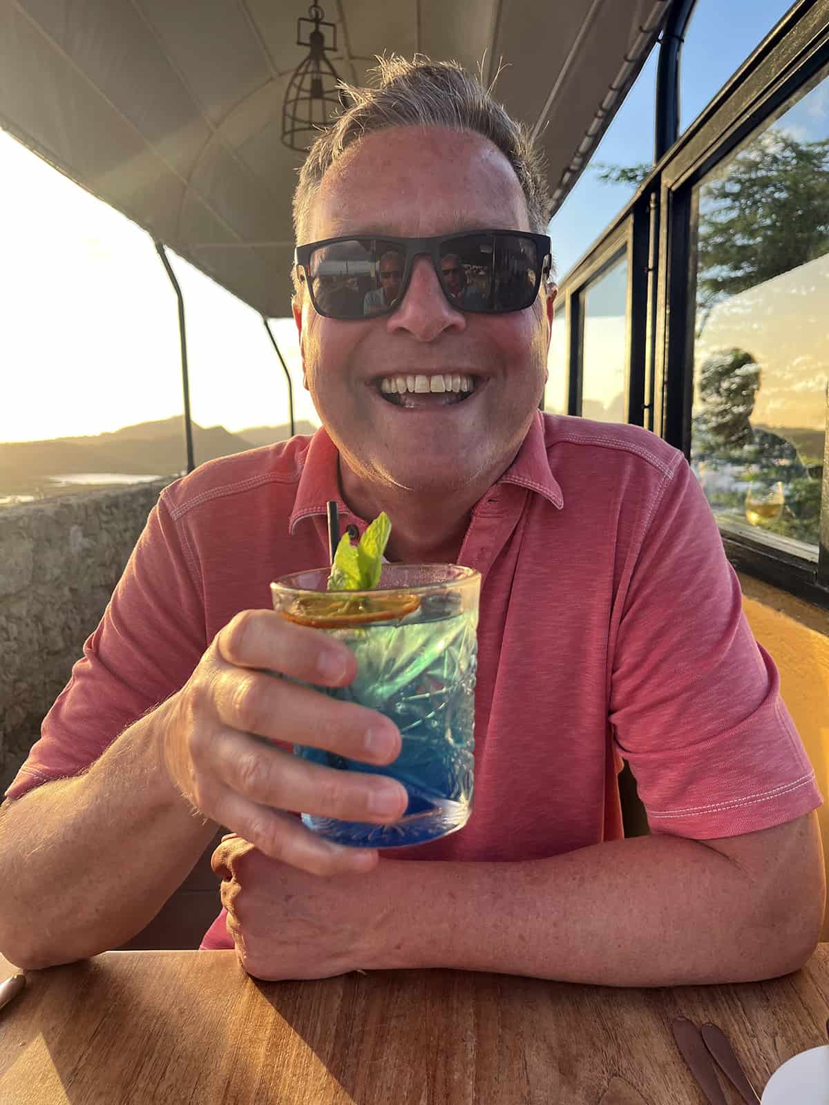 Tim enjoying a cocktail in a Curacao restaurant at sunset.
